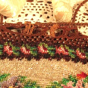 May include: A beaded purse with a brown crocheted top and floral design. The purse has a drawstring closure and a long brown cord.