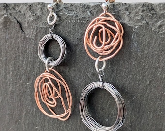 Mismatched knot ‘Contorto’ earrings; Mixed metal, copper, smoke and recycled silver; Statement circle knot earrings; Contemporary design
