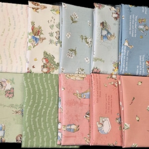 May include: Ten folded fabric swatches featuring Peter Rabbit illustrations and text. Patterns include cream, light blue, sage green, and dusty rose backgrounds with floral motifs, garden scenes, and printed storybook excerpts in various colors.