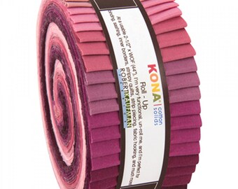 May include: A roll of fabric strips in a gradient of pink, magenta, and deep purple shades. The label reads Kona Cotton Solids Roll-Up, Robert Kaufman Fabrics, and specifies a size of 2-1/2 inches by WOF (44 inches) for quilting and sewing projects.