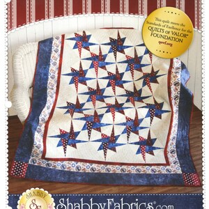May include: A patriotic quilt with a star pattern in red, white, and blue. The quilt features a cream-colored background with alternating red and blue starbursts. The border is a dark blue with red and white accents. The text "PATRIOTIC STARRY PATH" is at the top.