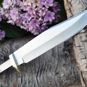 May include: A silver knife blade with a brass tang and a wooden handle. The blade is sharp and has a slight curve. The handle is made of wood and has a smooth finish.