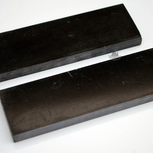 May include: Two black rectangular pieces of wood, possibly for crafting or woodworking projects.