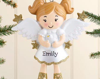 Könnte beinhalten: Ein hängender Engel-Weihnachtsbaumschmuck mit hellbraunem Haar in Zöpfen, weißen Flügeln und einem weißen Kleid, das den Namen Emily in schwarzer Schrift trägt. Die Figur hält einen kleinen weißen Vogel und trägt goldene Glitzerschuhe.