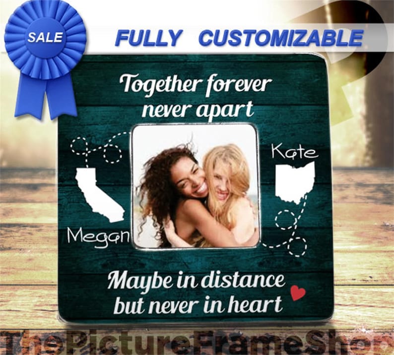 K&ouml;nnte beinhalten: Ein quadratischer Bilderrahmen mit dunkelblau-gr&uuml;nem Holzmaserungshintergrund. Er zeigt den Text Together forever never apart und Maybe in distance but never in heart. Enth&auml;lt wei&szlig;e Silhouetten von Kalifornien und Ohio mit Linien.