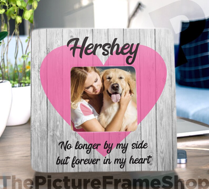 Pode incluir: Uma moldura de madeira com um cora&ccedil;&atilde;o rosa e uma foto de uma mulher e seu c&atilde;o. A moldura tem o texto "Hershey" e "No longer by my side but forever in my heart".