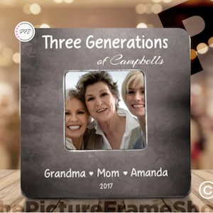 May include: A gray metal picture frame with a silver border and a cutout for a photo. The frame has the text "Three Generations of Campbells" at the top and "Grandma ♥ Mom ♥ Amanda 2017" at the bottom.