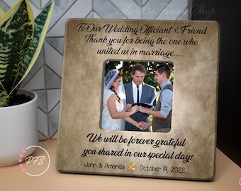 May include: A brown picture frame with a white mount and a photo of a wedding ceremony. The frame has the text "To Our Wedding Officiant & Friend Thank you for being the one who united us in marriage... We will be forever grateful you shared in our special day! John & Amanda October 19, 2022".