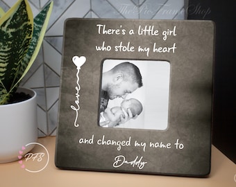 May include: A gray picture frame with a white heart balloon and the text "There's a little girl who stole my heart and changed my name to Daddy".