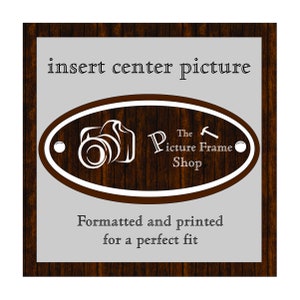 May include: A wooden picture frame with a gray center panel. The text "insert center picture" is at the top. An oval logo with a camera graphic and the text "The Picture Frame Shop" is in the center. The text "Formatted and printed for a perfect fit" is at the bottom.
