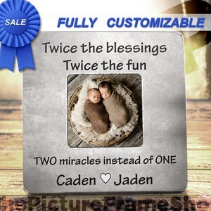 May include: A silver picture frame with a photo of twin babies. The frame has the text "Twice the blessings Twice the fun TWO miracles instead of ONE Caden Jaden" on it.