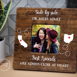 May include: A wooden picture frame with a rustic brown finish. The frame has two photo openings and the text "Side by side or miles apart, best friends are always close at heart".
