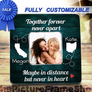 K&ouml;nnte beinhalten: Ein quadratischer Bilderrahmen mit dunkelblau-gr&uuml;nem Holzmaserungshintergrund. Er zeigt den Text Together forever never apart und Maybe in distance but never in heart. Enth&auml;lt wei&szlig;e Silhouetten von Kalifornien und Ohio mit gestrichelten Linien.