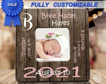 May include: A customizable wooden picture frame with a pink and white floral design. The frame features a photo of a baby girl, the text "Bree Hazel Hayes", "Tuesday 11:48 a.m.", "August 10, 2021", and "8 pounds 1 ounces 19 inches".