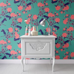 May include: White side table with a single drawer and ornate carvings. The table is in front of a teal wall with a pink floral pattern.