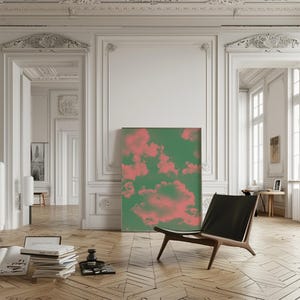 Puede incluir: Una silla de cuero negro con estructura de madera se encuentra en una habitaci&oacute;n con paredes blancas y molduras ornamentadas. Un gran cuadro abstracto con nubes rosas y verdes cuelga de la pared detr&aacute;s de la silla.