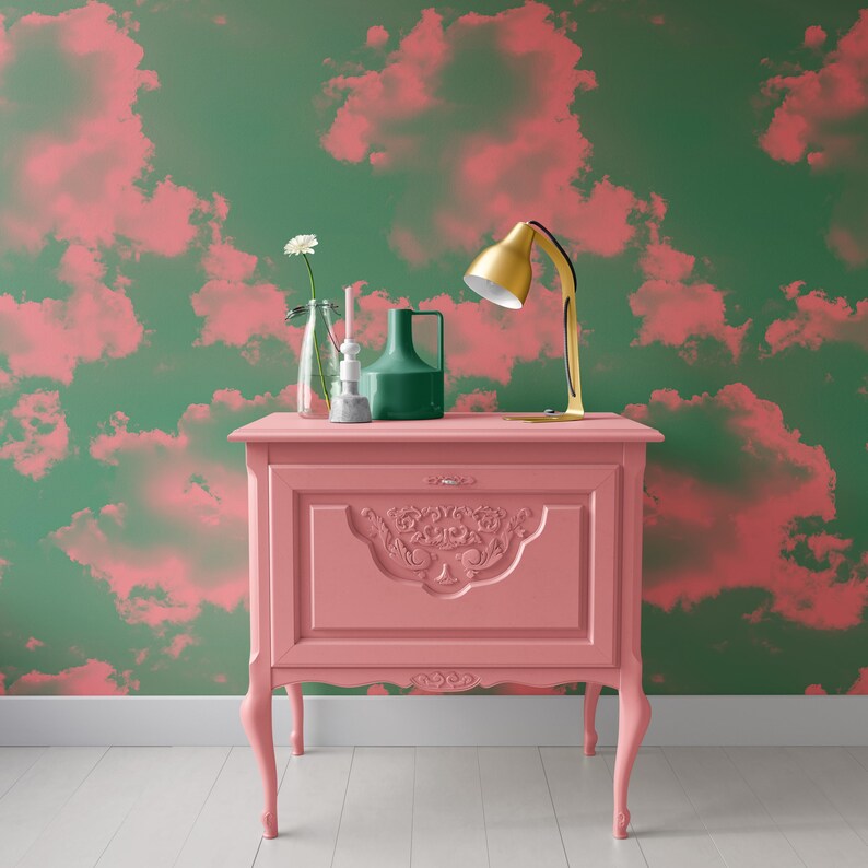 Puede incluir: Una mesa auxiliar antigua pintada de rosa con tallas ornamentadas y detalles dorados. La mesa tiene tres patas y est&aacute; decorada con una l&aacute;mpara, un jarr&oacute;n y una flor.