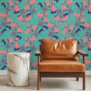 May include: A brown leather armchair with wooden legs sits in front of a teal wall with a pink floral pattern. A white marble side table is to the left of the chair.
