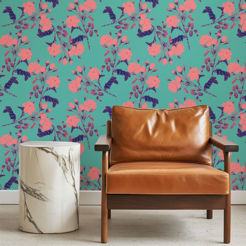 May include: A brown leather armchair with wooden legs sits in front of a teal wall with a pink floral pattern. A white marble side table is to the left of the chair.