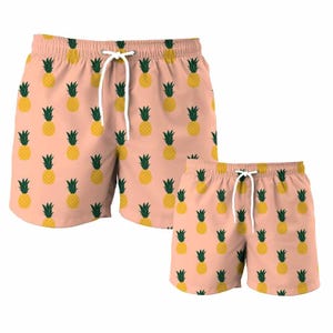 Può includere: Un paio di pantaloncini da bagno rosa con un motivo a ananas. I pantaloncini hanno un cordoncino bianco e sono disponibili in due taglie.