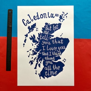 Puede incluir: Una impresi&oacute;n azul y blanca del contorno de Escocia con el texto "Caledonia" y una cita que dice "Pero d&eacute;jame decirte que te amo que pienso en ti todo el tiempo".