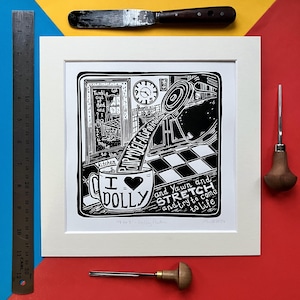 Puede incluir: Grabado en linóleo en blanco y negro de una escena de cocina con una taza que dice "I ♥ DOLLY" y el texto "and Yawn and STRETCH and try to come to life".