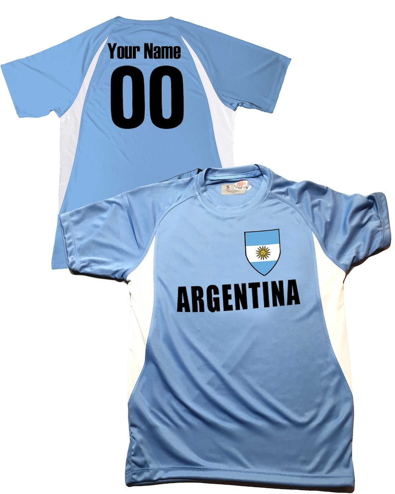 May include: Light blue soccer jersey with white accents and the Argentinian flag on the chest. The jersey has the text "ARGENTINA" and a number "00" on the back. The text "Your Name" is above the number.