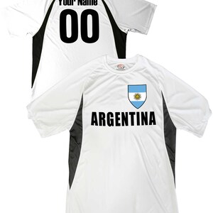May include: White soccer jersey with black accents and the text "ARGENTINA" and the Argentinian flag on the front. The back of the jersey has the text "Your Name" and the number "00".