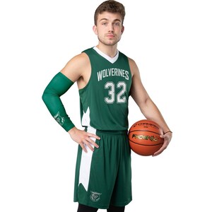 Puede incluir: Un uniforme de baloncesto verde con detalles blancos. La camiseta dice "Wolverines" y tiene el n&uacute;mero 32 en blanco. Tambi&eacute;n se ve una manga de brazo verde y una pelota de baloncesto con "Phoenix".