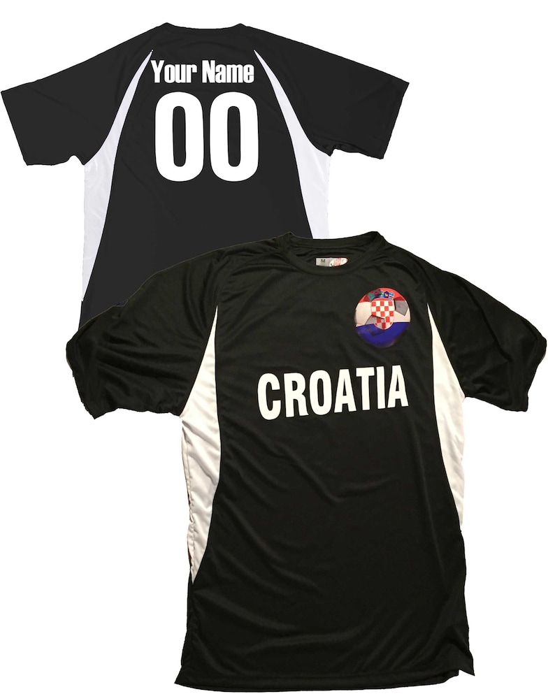 Puede incluir: Camiseta de f&uacute;tbol negra con detalles blancos y la palabra "CROACIA" impresa en la parte delantera. La camiseta presenta un bal&oacute;n de f&uacute;tbol con la bandera croata.