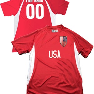 May include: Red soccer jersey with white accents and the word "USA" on the front. The back of the jersey has a white number "00" and the text "Your Name".