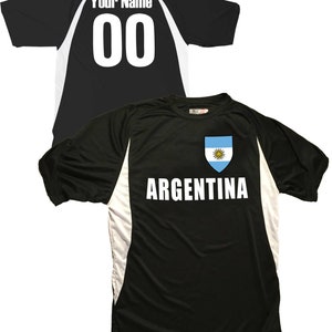 May include: Black soccer jersey with white accents and the word "ARGENTINA" printed on the front. The jersey features a small patch with the Argentinian flag on the chest. The back of the jersey has a white number "00" and the text "Your Name" printed on it.