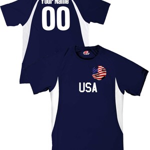 May include: A navy blue soccer jersey with white accents. The jersey has a soccer ball with an American flag on it and the word "USA" printed on the front. The back of the jersey has a white number "00" and the words "Your Name" printed on it.