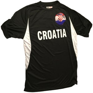 Puede incluir: Camiseta de f&uacute;tbol negra con detalles blancos y la palabra "CROACIA" impresa en la parte delantera. Un bal&oacute;n de f&uacute;tbol con la bandera croata est&aacute; impreso en el pecho izquierdo.