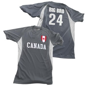 May include: Two gray athletic shirts. One shirt has "CANADA" in white letters with a red and white maple leaf emblem. The other shirt has "BIG BRO" and the number "24" in white. Both shirts have white side panels.