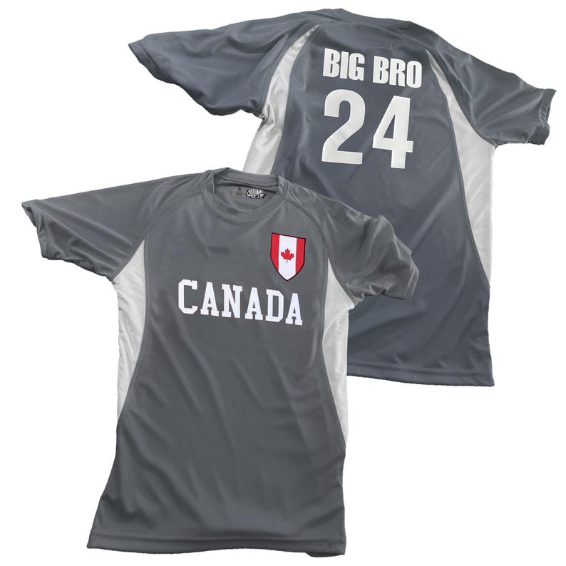May include: Two gray athletic shirts. One shirt has "CANADA" in white letters with a red and white maple leaf emblem. The other shirt has "BIG BRO" and the number "24" in white. Both shirts have white side panels.