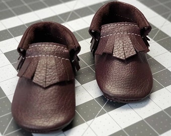 Baby moccasin pattern to make baby shoes. Grab the baby bootie pattern and print the baby shoe template for a baby birtday outfit now!