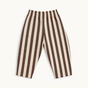 May include: A pair of pants featuring a vertical striped pattern in dark brown and off-white. The garment has a high-rise elastic waistband with gathered fabric detailing and straight-cut legs that taper slightly toward the bottom hem.