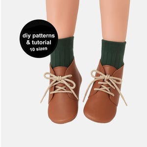 Può includere: Stivaletti da bambino in pelle marrone con lacci color crema, abbinati a calzini a coste verde scuro. Un cerchio nero con testo bianco recita: "diy patterns & tutorial 10 sizes."