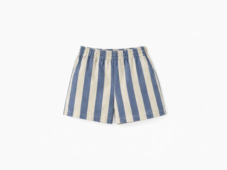 May include: A pair of shorts featuring a vertical striped pattern in blue and off-white. The garment has an elasticized waistband with gathered fabric detail and a straight-cut hemline, constructed from a woven textile material.