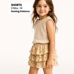 Op de afbeelding: Een jong meisje draagt een beige mouwloze trui en een rok met ruches met een bloemenpatroon. De rok is beige met een gele bloemenprint. De tekst "SHORTS 0 Mos - 14 Sewing Patterns" is inbegrepen.