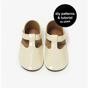 Può includere: Un paio di scarpine color crema con design a T-bar. Le scarpe hanno una finitura lucida e un interno marrone a contrasto. Un cerchio nero con testo bianco recita "diy patterns & tutorial 10 sizes".