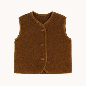 May include: A sleeveless vest in a deep brown color with a textured, fleece-like surface. The garment features a rounded neckline, a front opening secured by three matching brown snap buttons, and finished edges with a smooth brown trim.