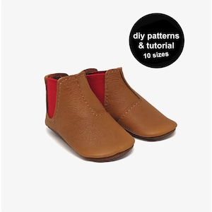 Puede incluir: Botines de bebé de cuero marrón con paneles laterales elásticos rojos. La imagen incluye un círculo negro con texto blanco: "diy patterns & tutorial 10 sizes". Botines cómodos y elegantes.
