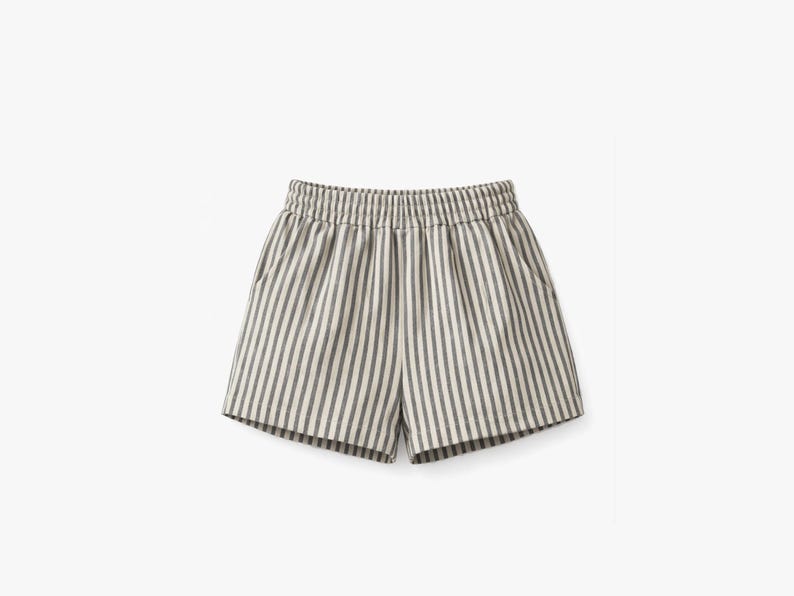 May include: A pair of shorts featuring a vertical pinstripe pattern in dark gray and off-white. The shorts have an elasticized waistband with gathered fabric detail and two side pockets, designed with a straight-cut hemline and a relaxed fit.