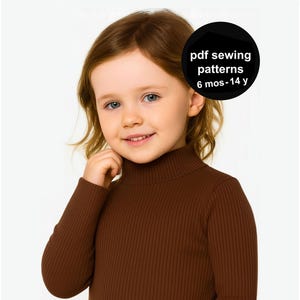 Peut inclure: Une jeune enfant portant un pull à col roulé côtelé marron. L'image comprend un cercle noir avec le texte blanc qui dit "pdf sewing patterns 6 mos-14 y". L'enfant a les cheveux châtain clair et sourit.