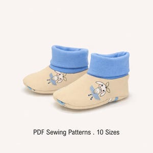 Może przedstawiać: Para beżowych bucików niemowlęcych z jaskrawoniebieskimi mankietami i grafiką królika z kreskówki z przodu. Tekst pod bucikami brzmi PDF Sewing Patterns . 10 Sizes. Buciki wykonane są z miękkiej tkaniny i mają zaokrąglony kształt nosków.