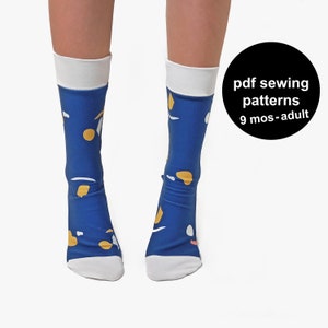 Puede incluir: Un par de calcetines azules con un puño blanco y un patrón abstracto colorido. Los calcetines están sobre un fondo blanco.  pdf sewing patterns 9 mos-adult