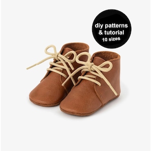 Può includere: Un paio di stivaletti da bambino in pelle marrone con lacci beige. Gli stivaletti sono mostrati su sfondo bianco. Un cerchio nero con testo bianco recita "diy patterns & tutorial 10 sizes."