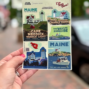 May include: A sheet of UV waterproof stickers featuring Maine landmarks. The stickers include images of lighthouses, houses, and boats, with text that reads "MAINE" and "The Way Life Should Be." The stickers are designed for water bottles, phones, and laptops.